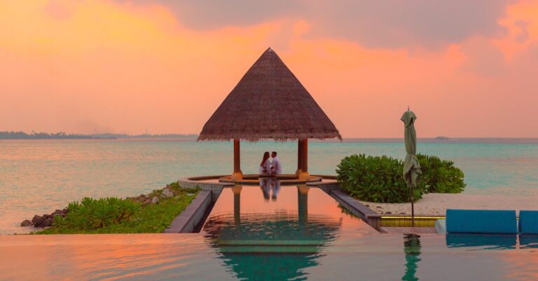 Couple Under Hut Beside Sea and Infinity Pool