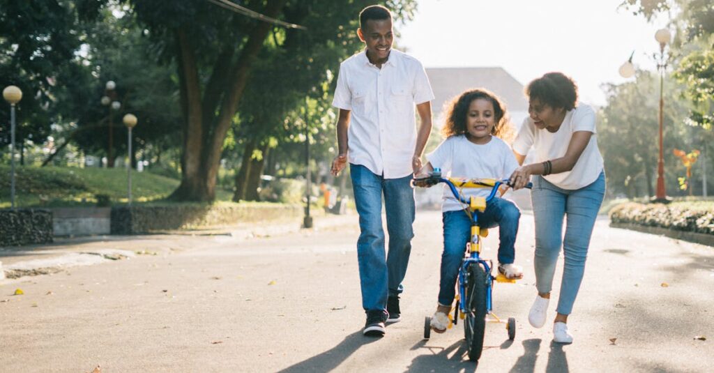 Man Standing Beside His Wife Teaching Their Child How to Ride Bicycle