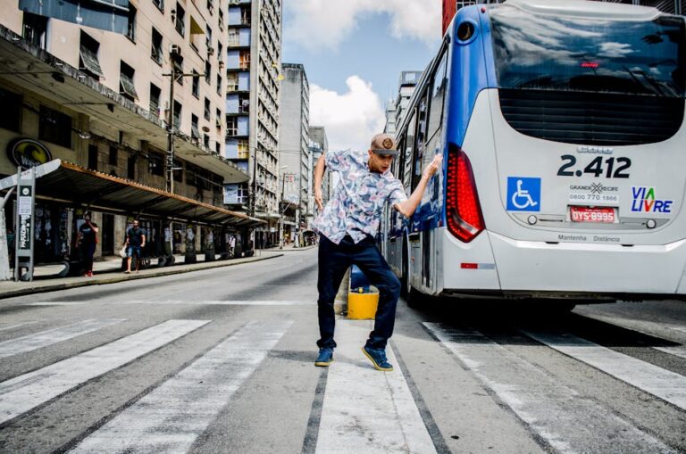 Man Dancing on Pedestrian Crossing Near Bus