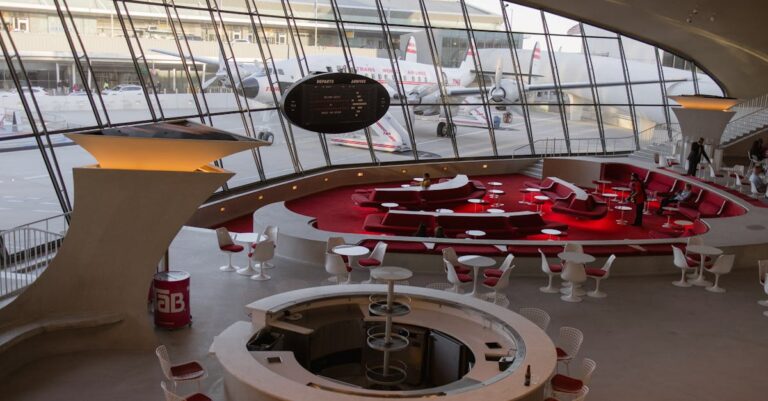 A large circular table with chairs and a large window