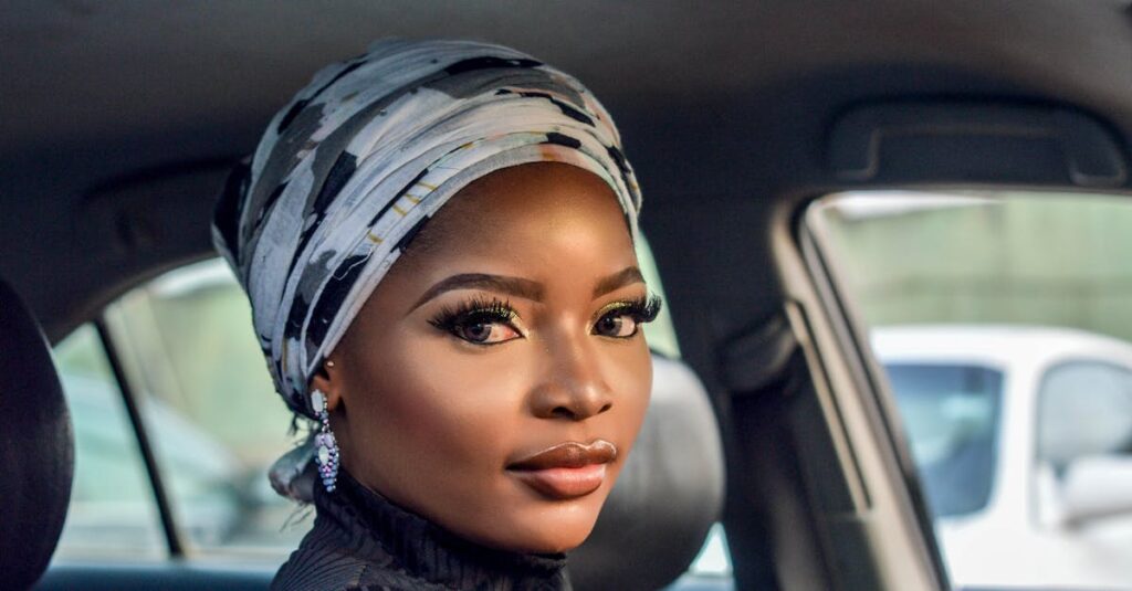 Photo of Woman Wearing White and Black Floral Headscarf Inside Car