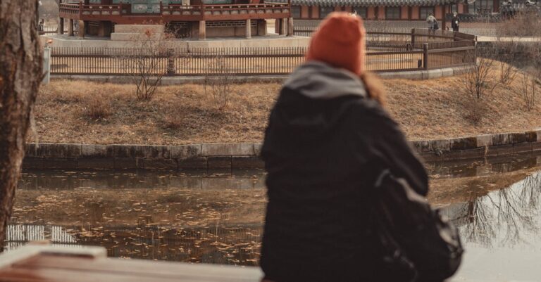 Gyeongbokgung Palace behind Woman Sitting in Jacket