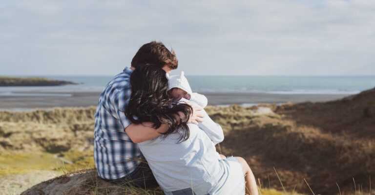 Man and Woman Sitting on Stone Carrying Baby