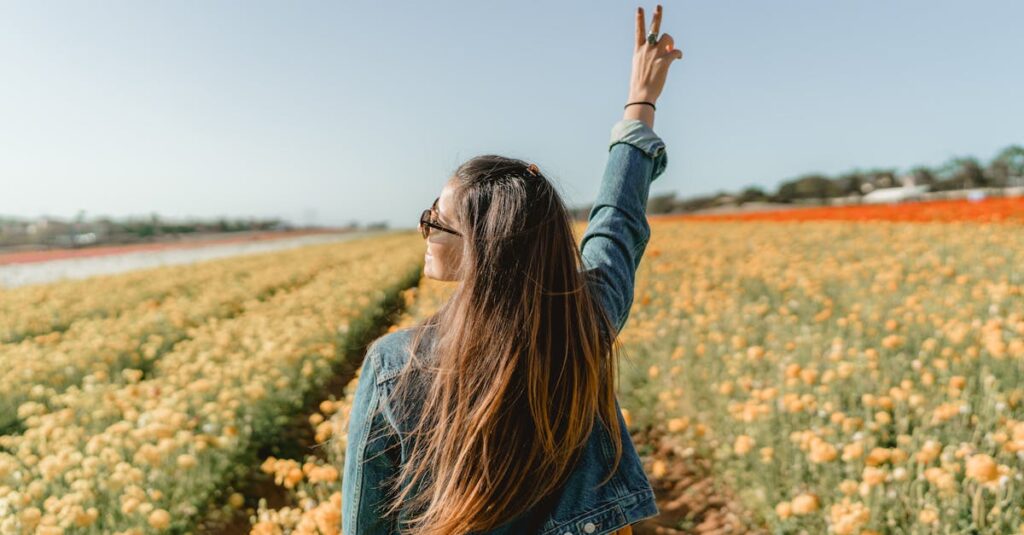 Woman Standing On Yellow Petaled Flower Garden Raising Hand