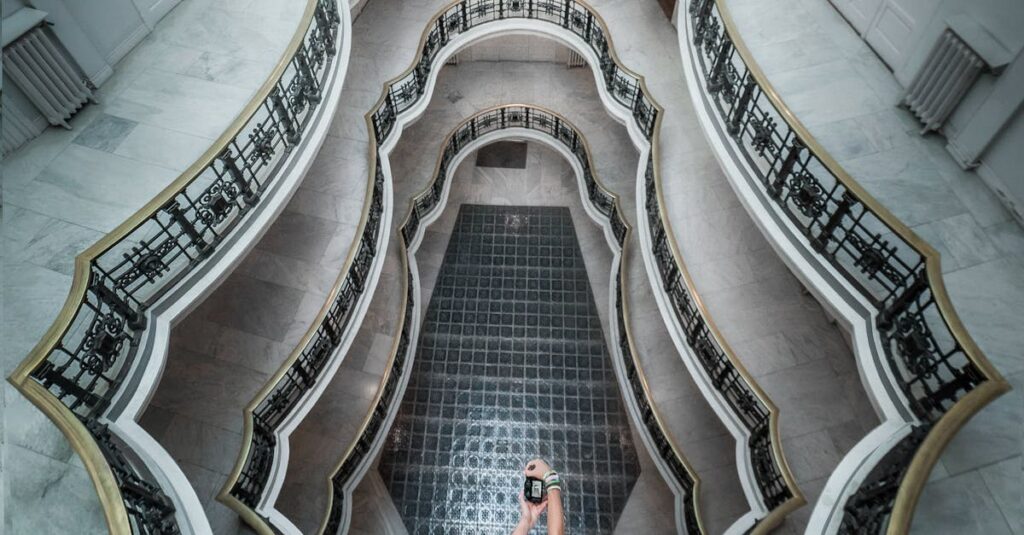 A person taking a picture of a spiral staircase