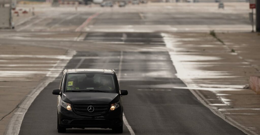 A small car driving on a wet runway