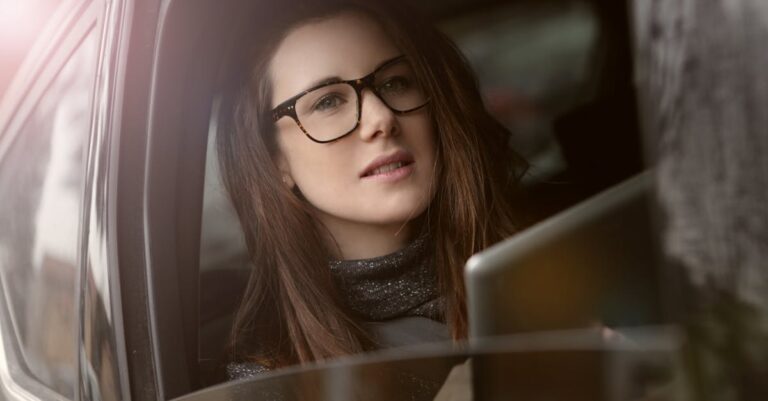 Woman in Black Framed Eyeglasses Holding Silver Tablet