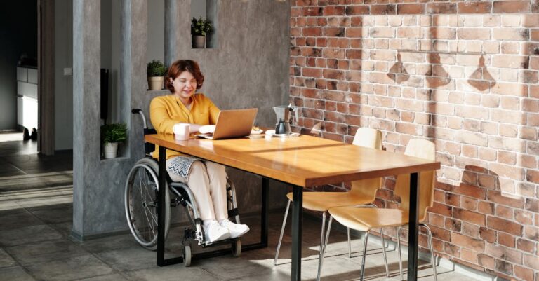 Woman Sitting on Wheelchair While Using Laptop