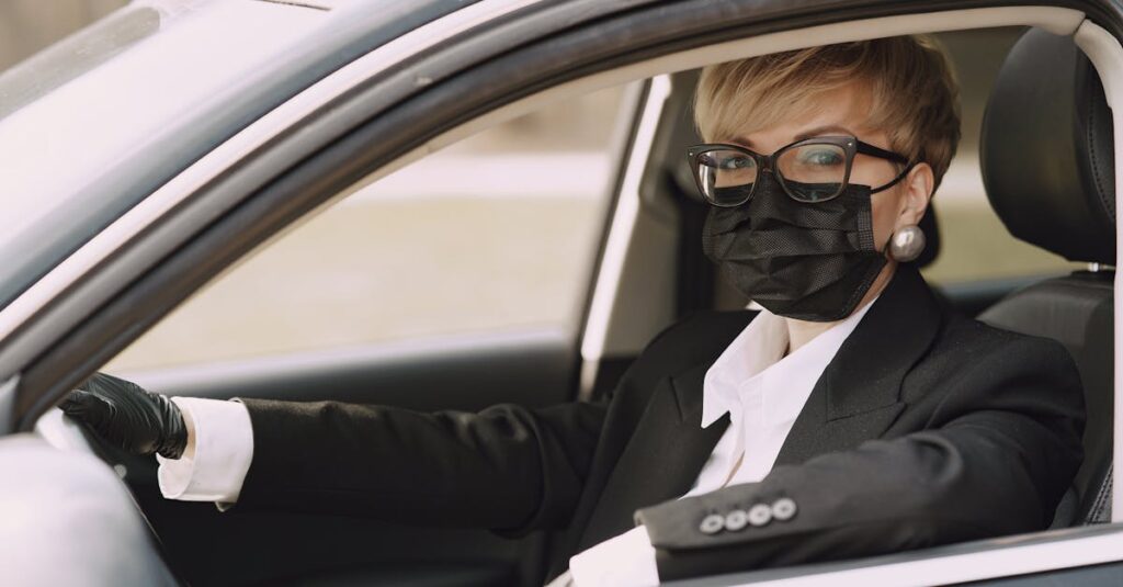 Serious female driver in protective mask and gloves in car