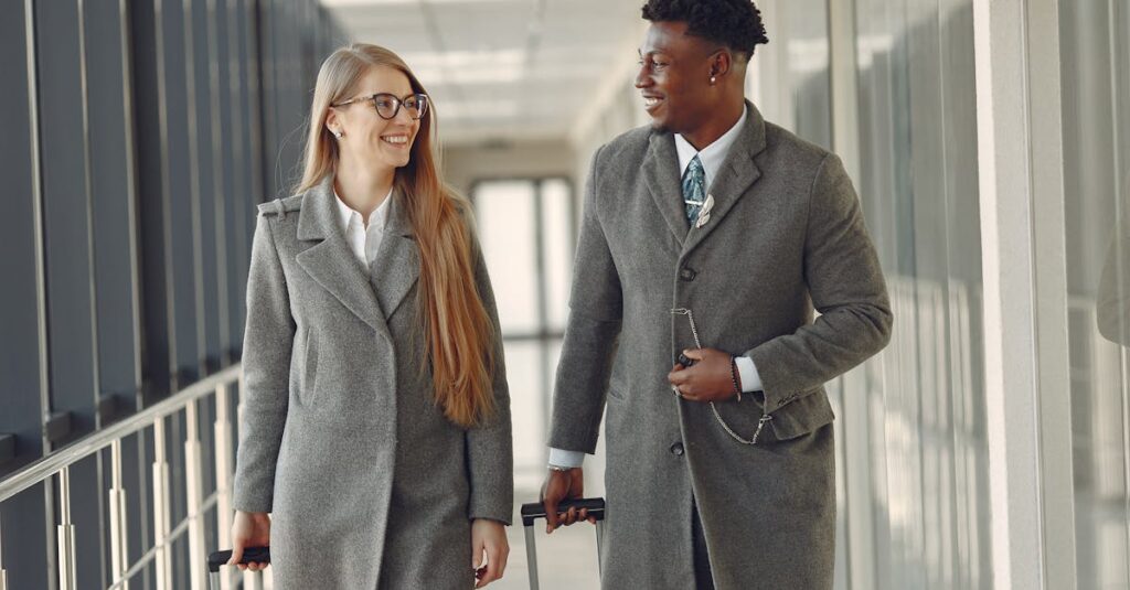 Stylish colleagues walking along airbridge in airport