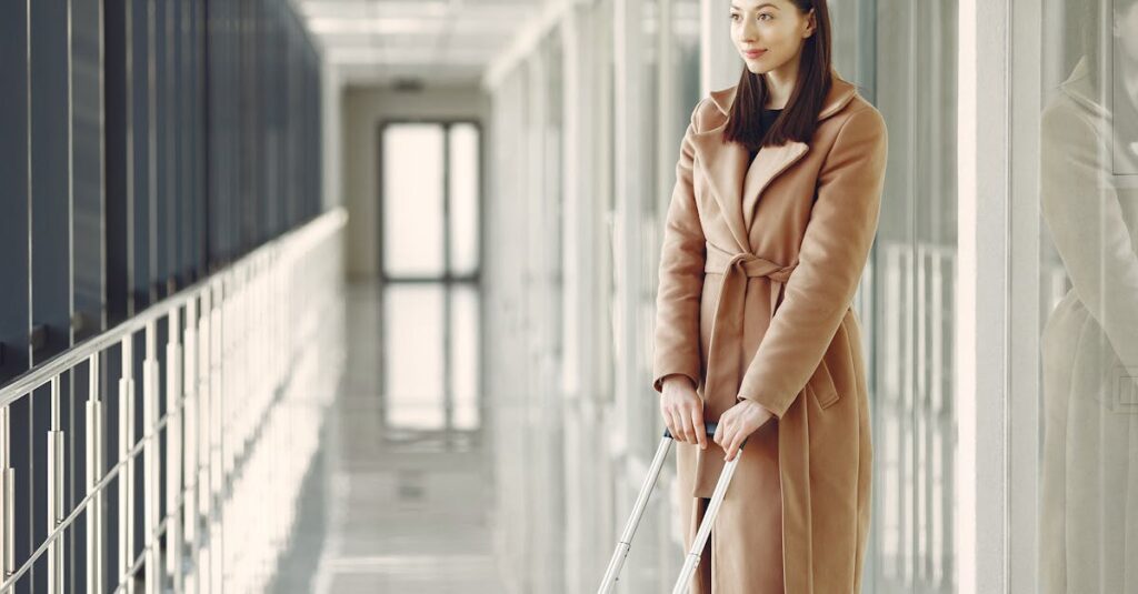 Content woman with suitcase waiting for boarding in airport