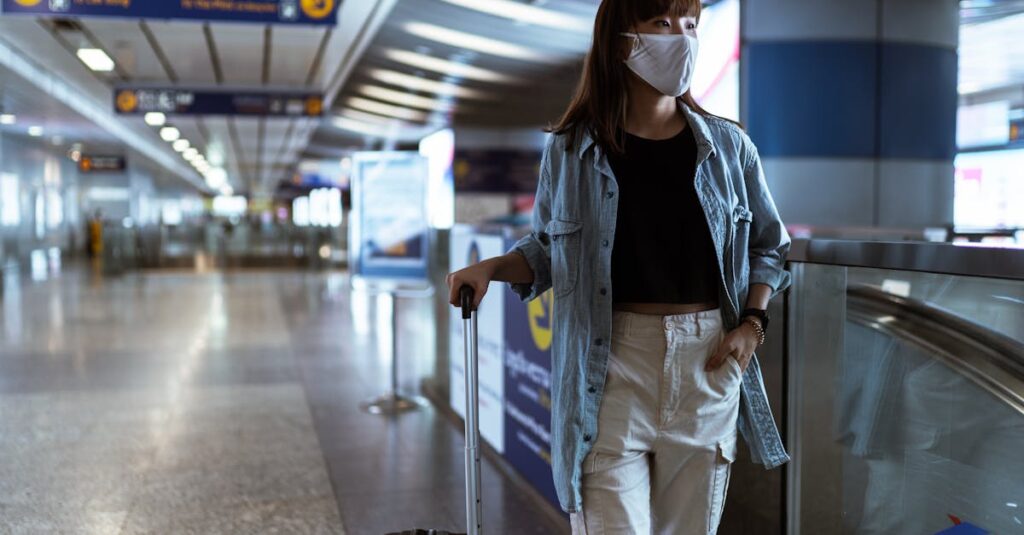 Woman With a Face Mask Holding her Luggage