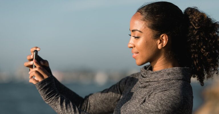 Side View of a Woman Taking Pictures with her Smartphone