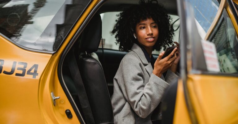 Black woman getting out of taxi on street