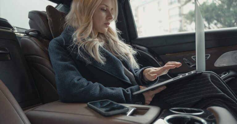 Woman Using Laptop While In The Car