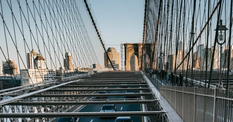 Metal suspension bridge with traffic in city