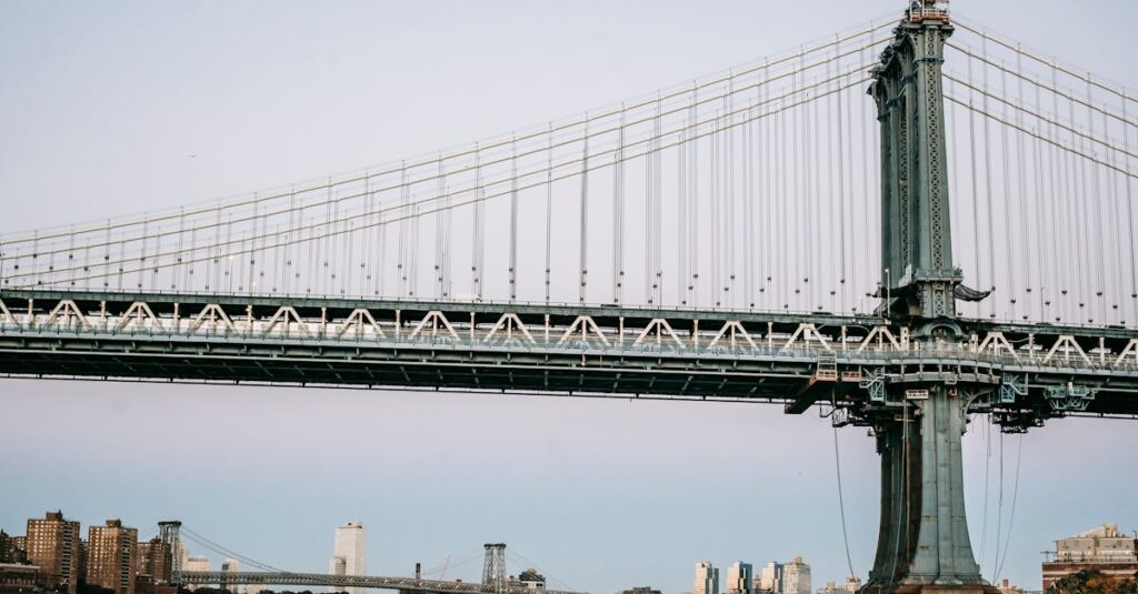 Low angle of massive bridge with metal constructions over river in modern city