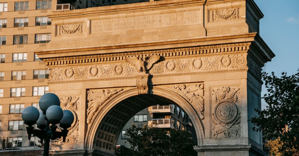 From below of aged triumphal arch placed in Washington Square Park in New York City against residential building illuminated by sunlight