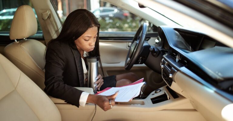 Woman Reading Documents while in Her Car