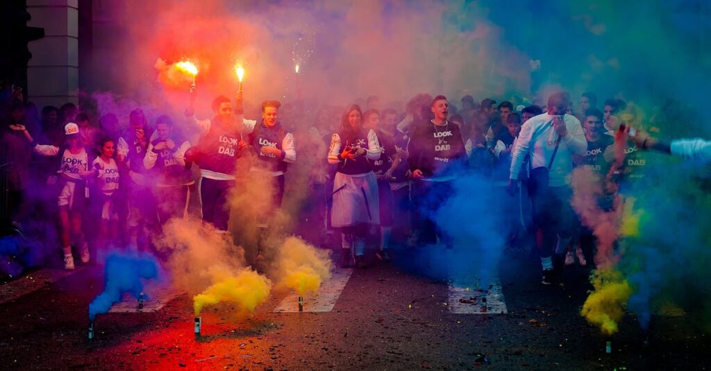 Group of People on Road With Assorted-color Smokes