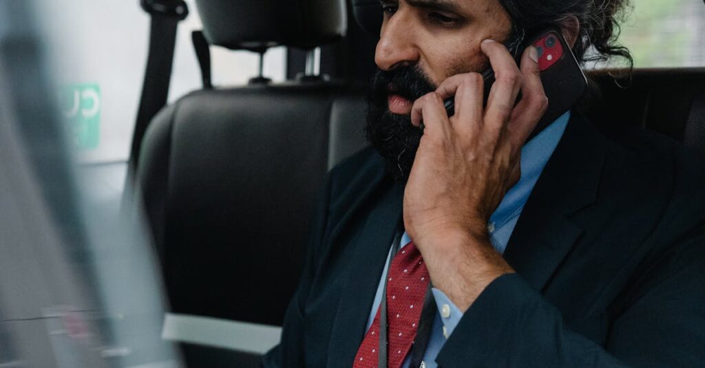 Man in Suit sitting inside Car talking on Phone