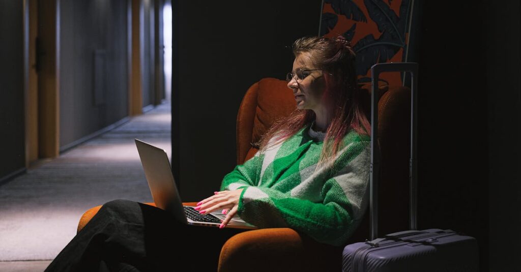 Woman Sitting in Corner of Hotel Hallway Working on Laptop