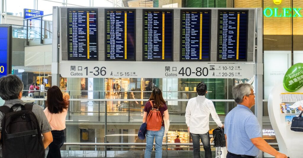 People Standing Near Airport Departure Board