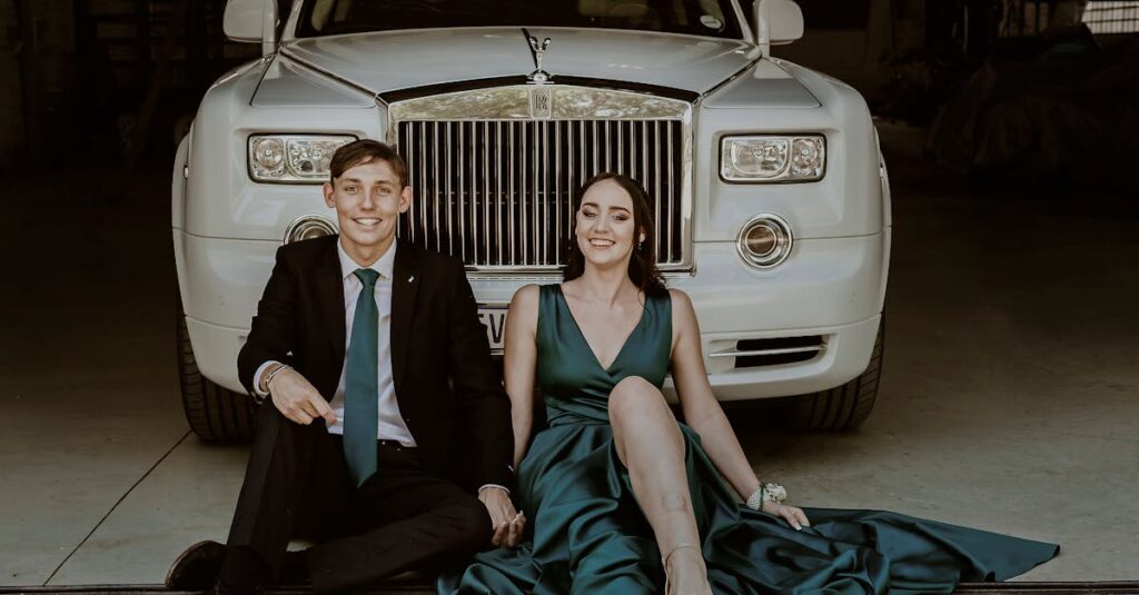 Smiling Couple Sitting by Rolls Royce Car