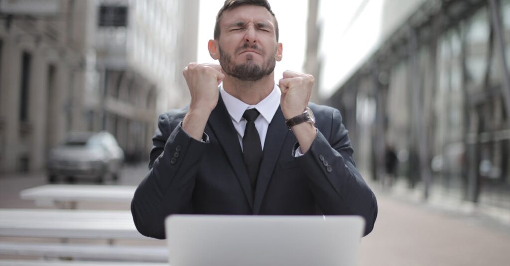 Man in Black Suit Sitting on Chair Beside Buildings