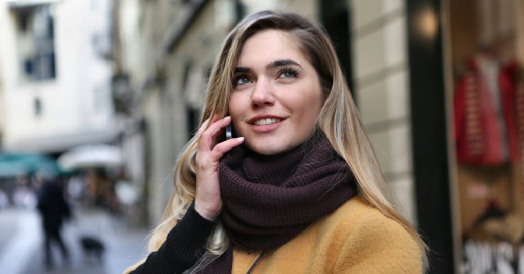 Woman in Brown Scarf and Black Coat Looking Up The Sky