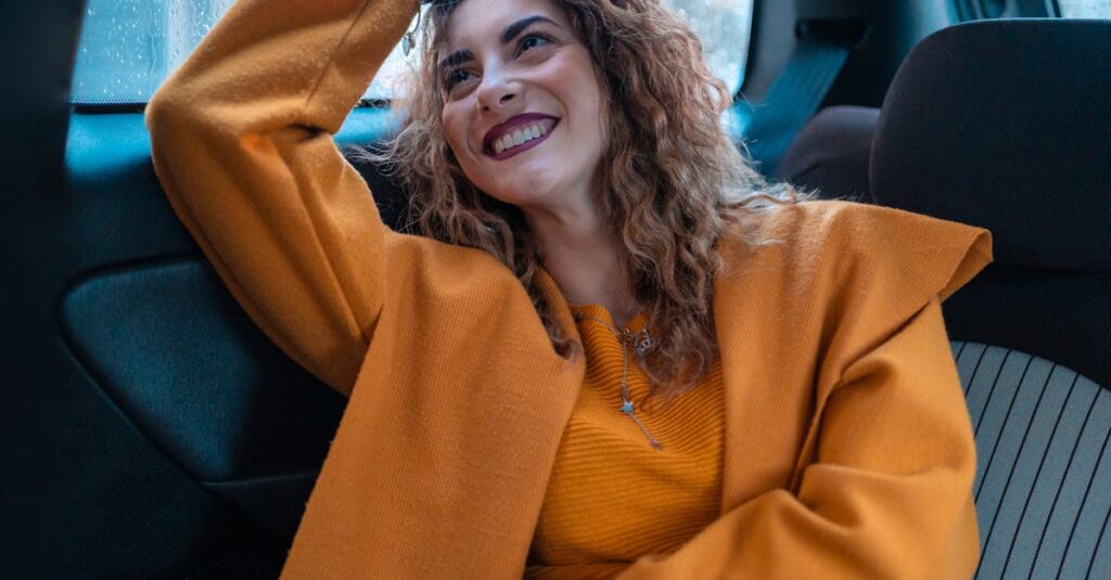 Woman in Orange Coat Sitting on Blue Car Seat