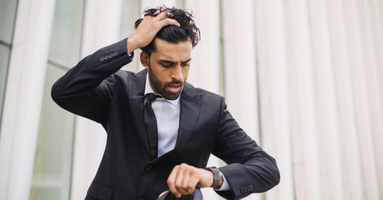 A Bearded Man in a Suit Looking at His Watch