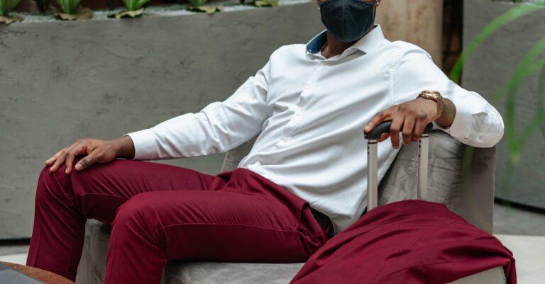 Man Wearing Black Face Mask Sitting on Sofa