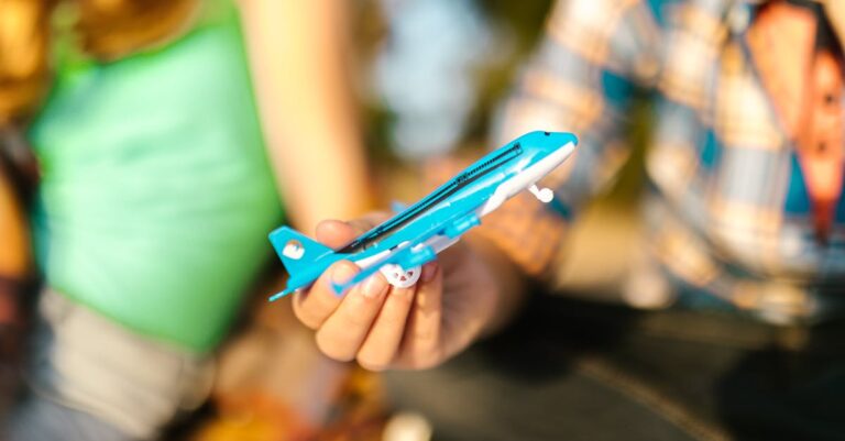 Close-Up Shot of a Person Holding an Airplane Toy