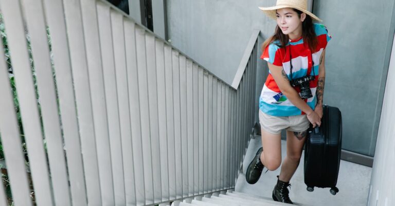 A Beautiful Woman Wearing a Straw Hat Carrying a Suitcase while Walking Up the Stairs