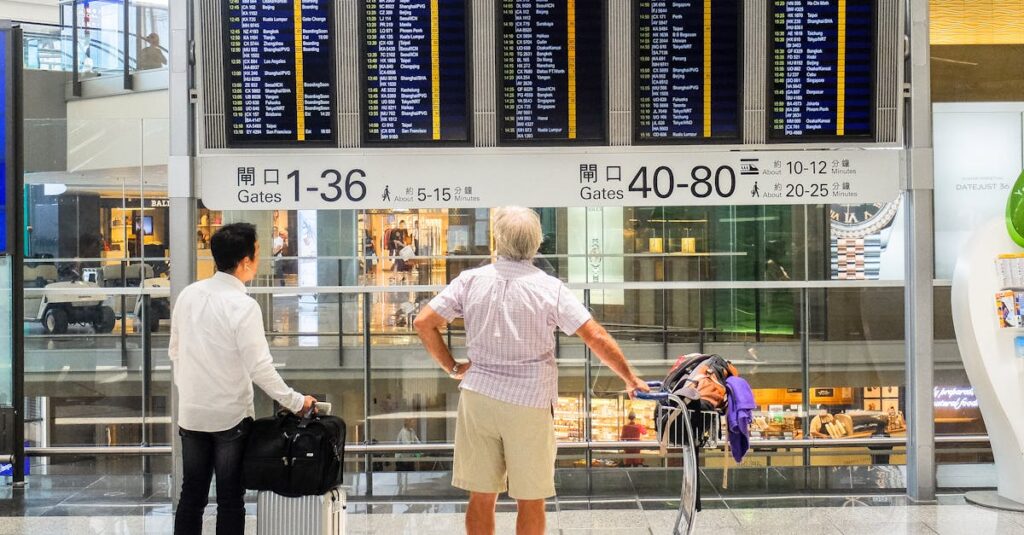 Passengers review flight information on a digital board in Hong Kong airport terminal.