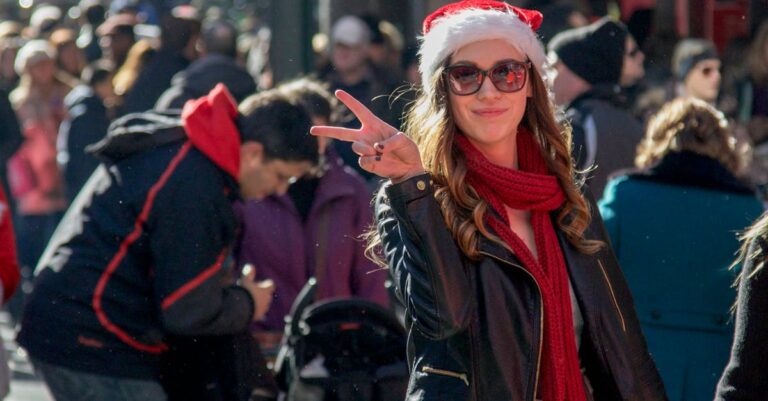 Woman in a Santa Hat Standing in the Crowd on the Street