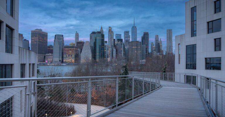 Capture of the iconic Manhattan skyline seen from a bridge at dusk.