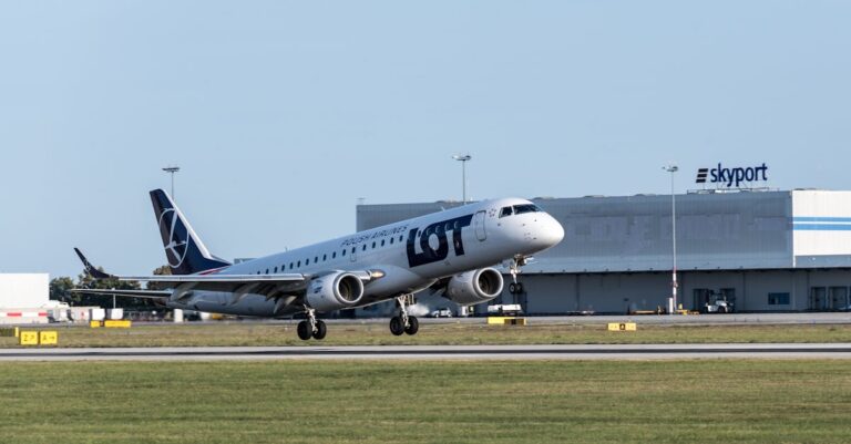 A LOT Polish Airlines plane taking off from Hamburg Airport, Germany in clear daylight.