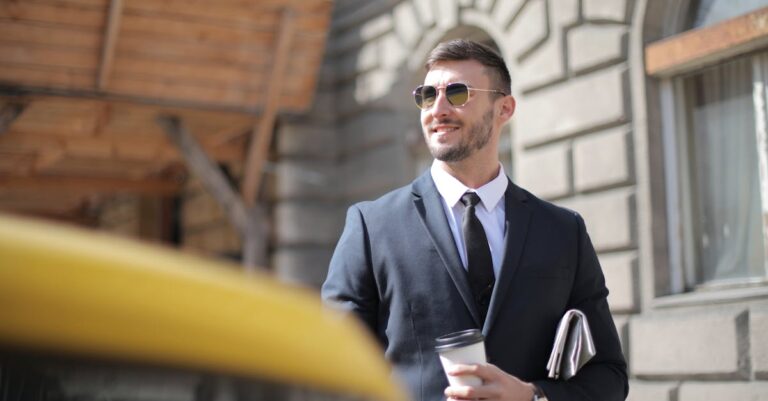 Man In Black Suit Holding A Cup Of Coffee