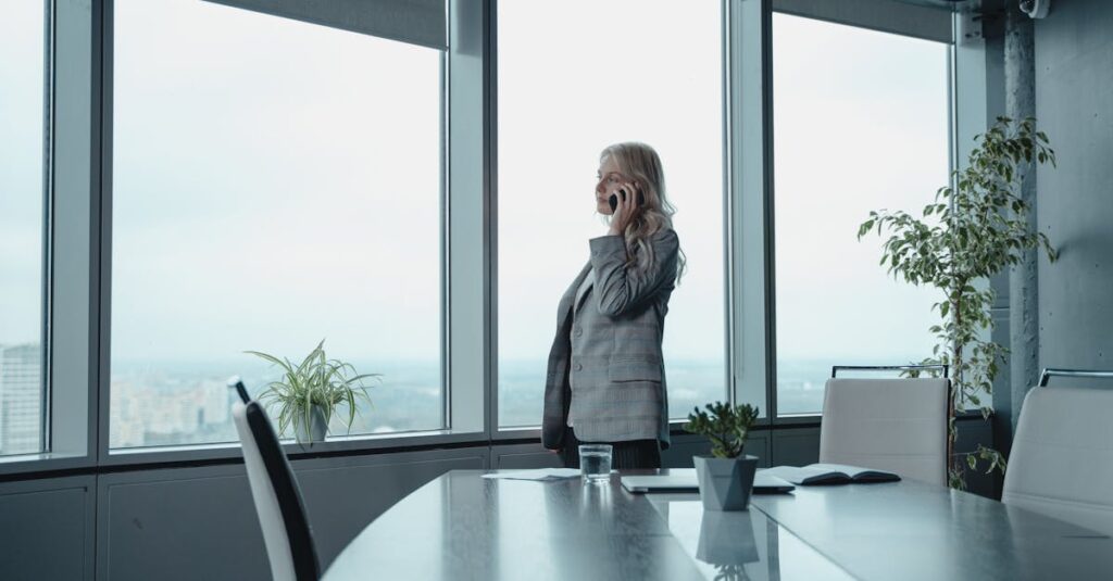 Woman In Gray Coat Standing Near Glass Window