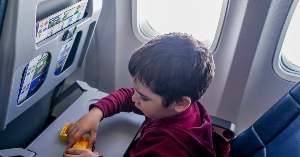 A young boy engrossed in playing with toy blocks on an airplane during a flight.