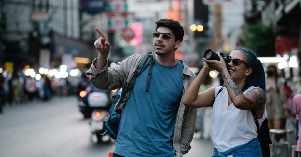 Two tourists capturing street scenes in a busy city, enjoying travel moments.