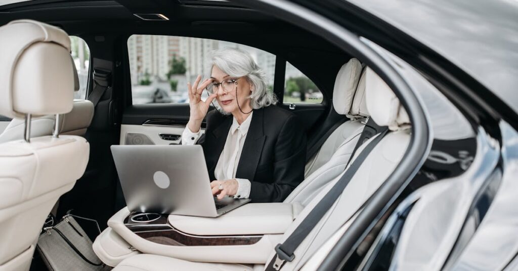 Woman in Luxury Car Using Laptop