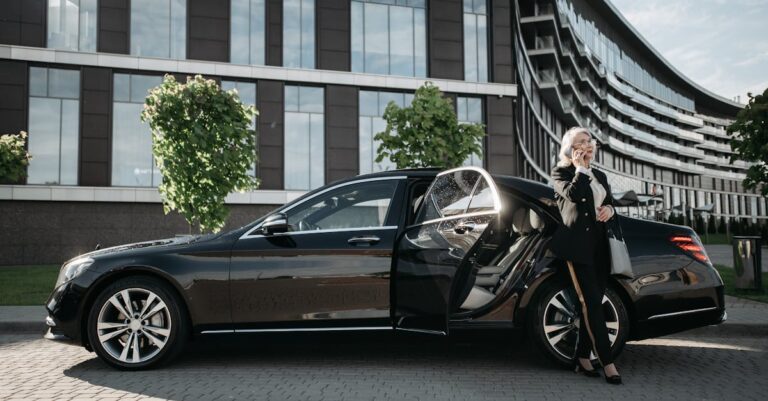 Woman in Black Suit Standing Beside Black Car Using Cellphone