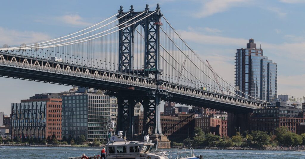 NYPD patrol boat cruising near the iconic Manhattan Bridge on a sunny day in New York City.