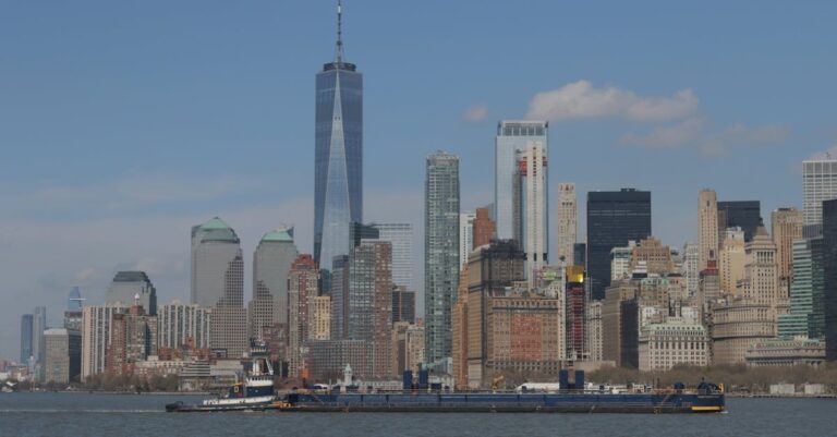 Stunning view of the New York City skyline featuring the iconic One World Trade Center across the Hudson River.