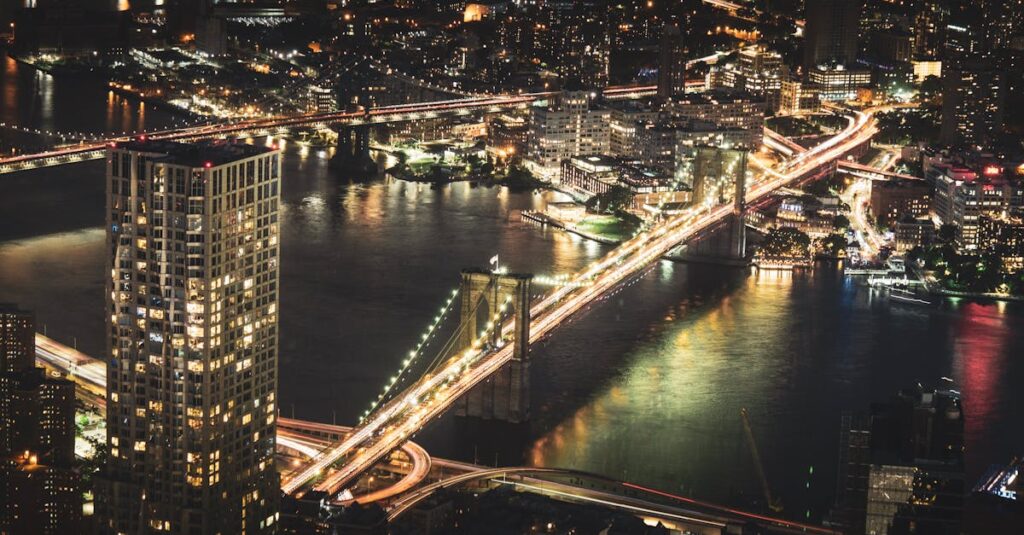 A breathtaking aerial view of Brooklyn Bridge illuminated at night, showcasing New York City's vibrant skyline.