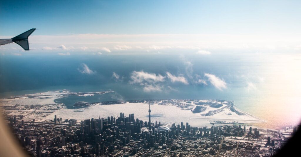 A stunning aerial view of Toronto skyline with the CN Tower and snowy landscape, seen from an airplane.