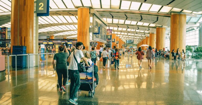 Travelers bustling through Singapore Changi Airport terminal, highlighting the dynamic and vibrant atmosphere of international travel.